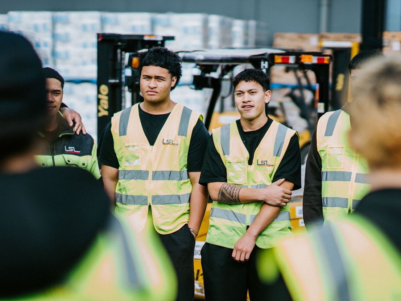 LSL crew members in the yard with a forklift behind them